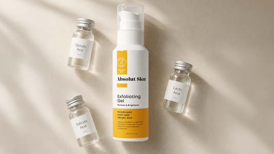 Absolut Skin Exfoliating Gel surrounded by three labeled vials representing glycolic, lactic, and salicylic acid on a warm off-white surface.